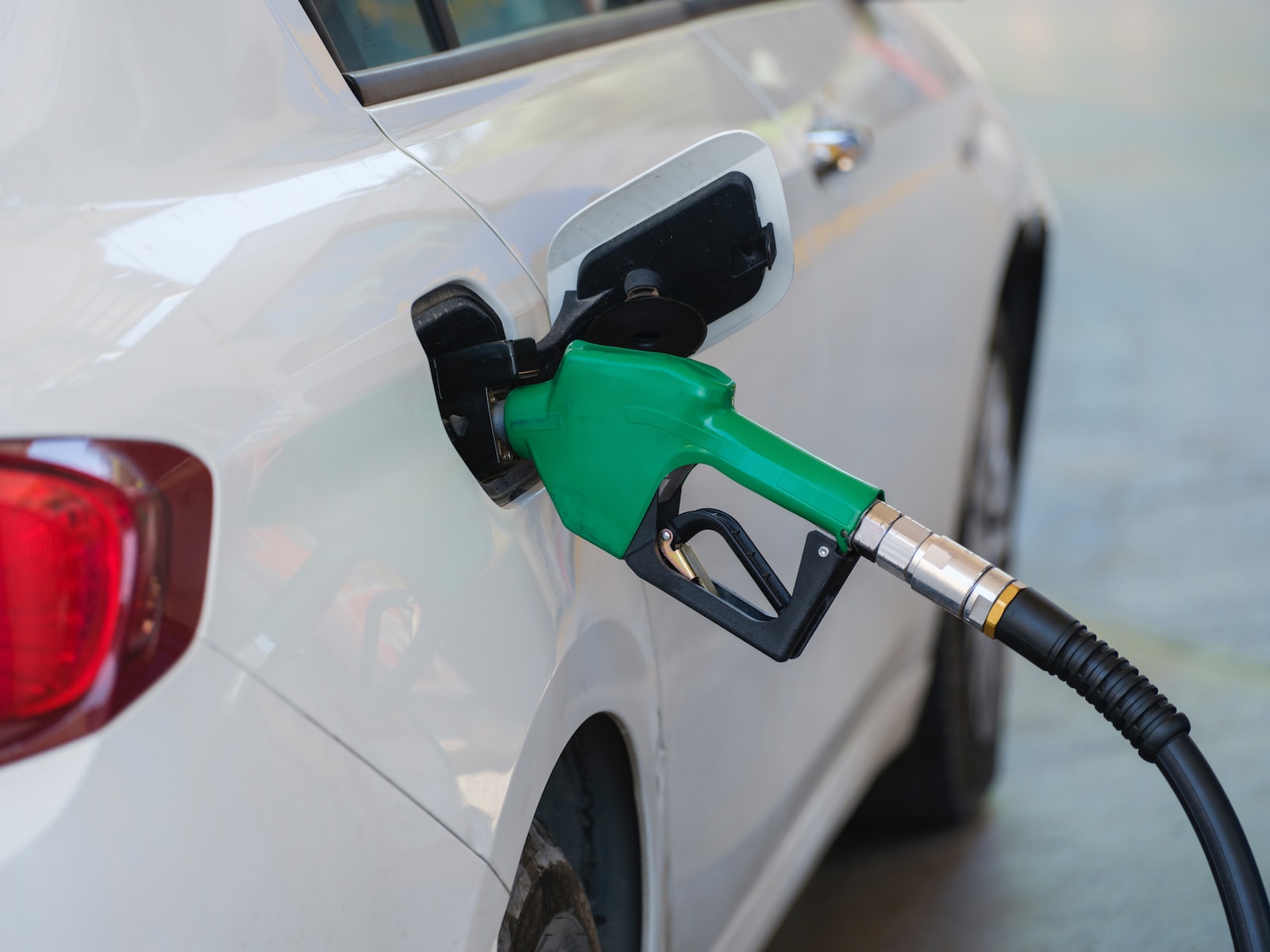 a white car with a green gas pump