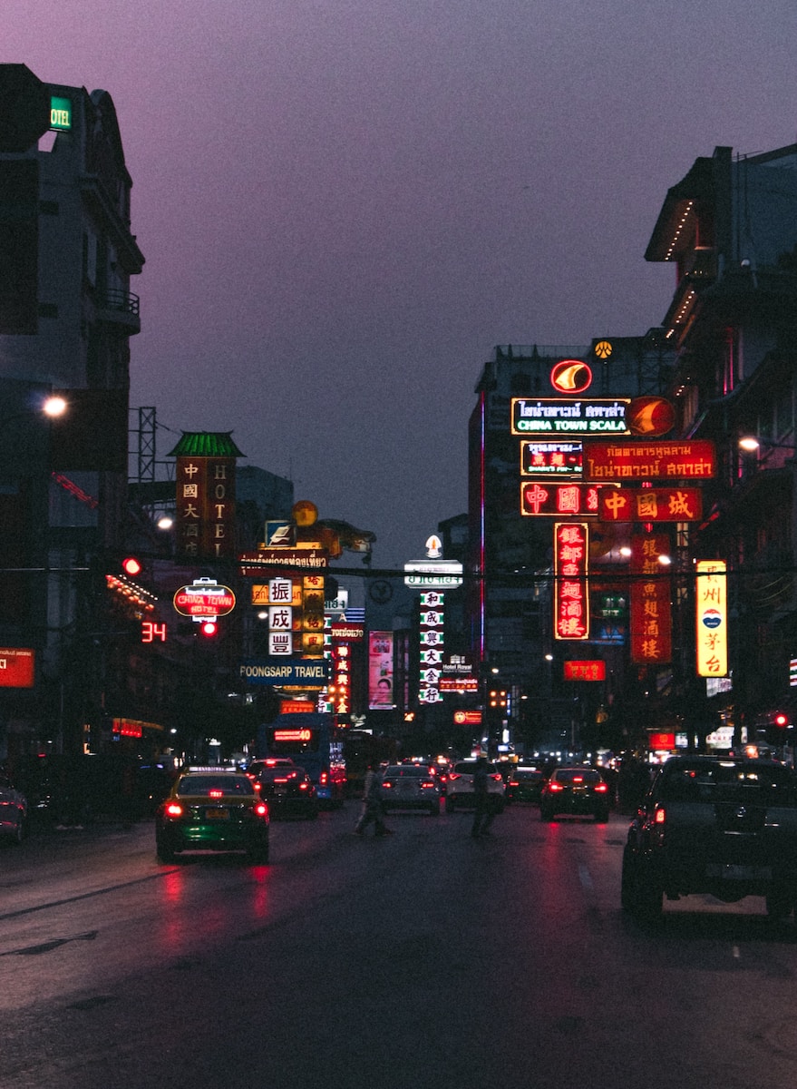 cars on road near high rise buildings during night time